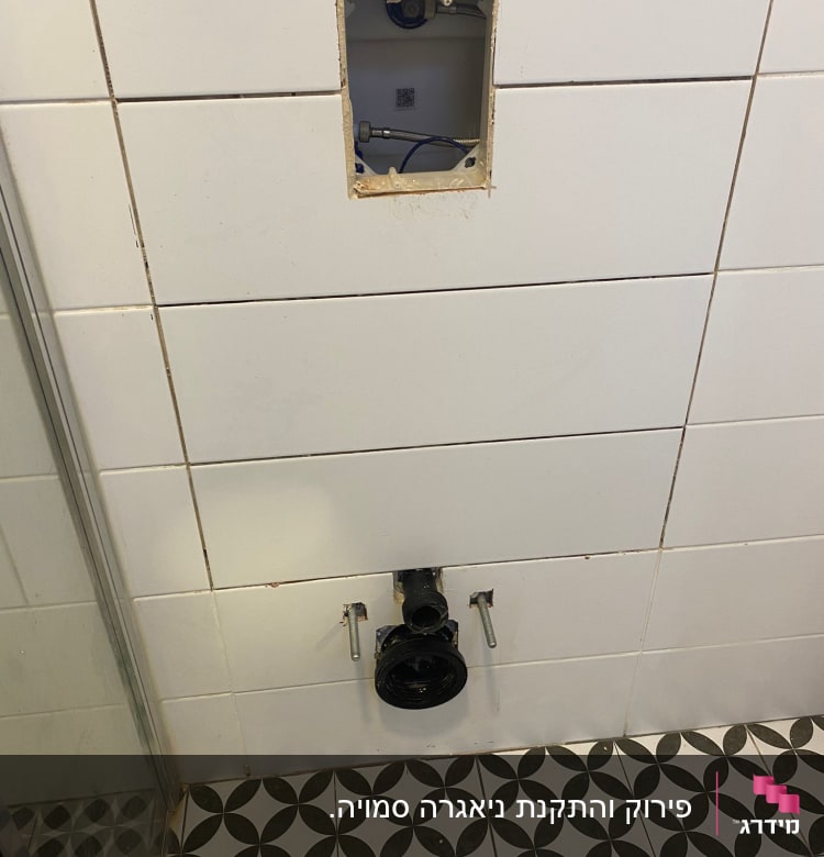 צנרת חשופה בקיר אריחים בחדר אמבטיה